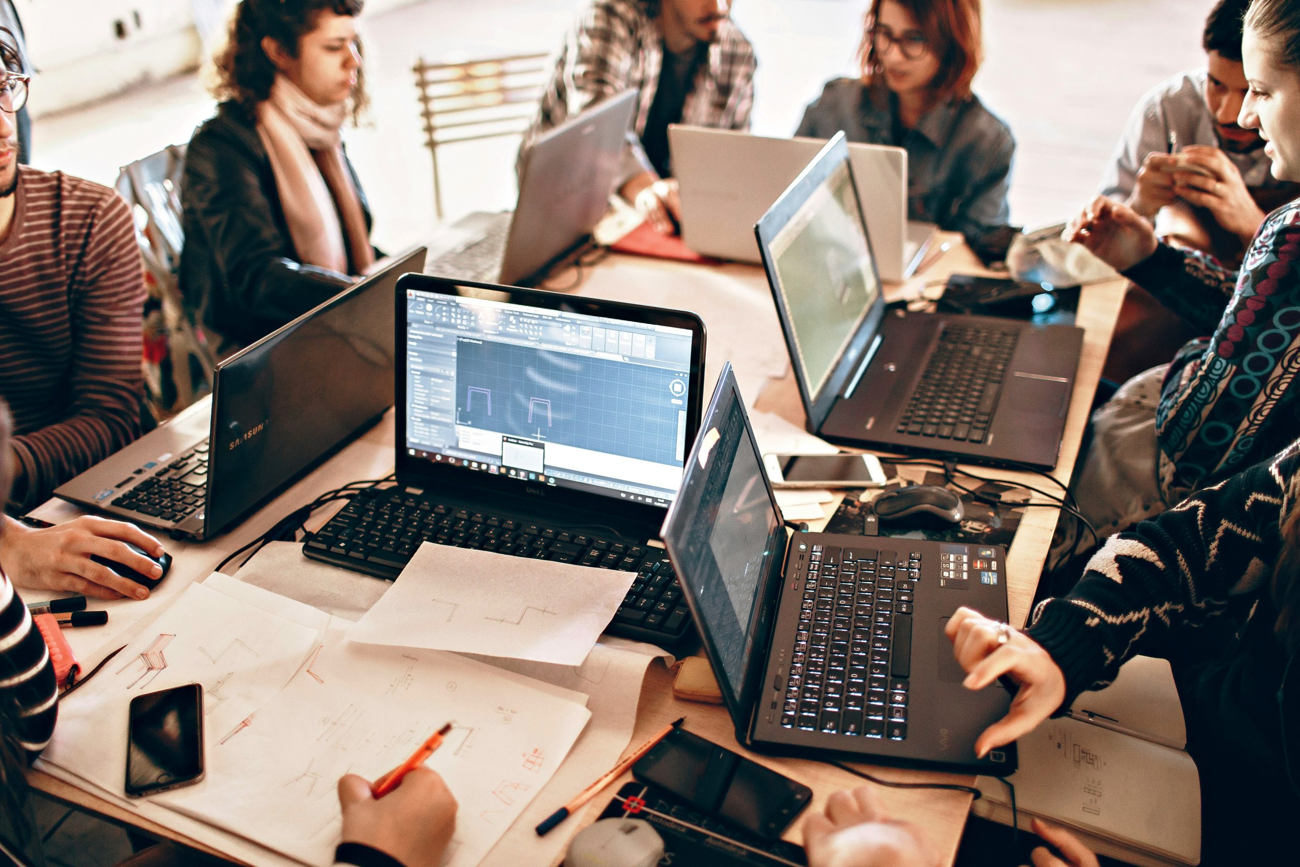 Menschen arbeiten gemeinsam an einem Tisch und diskutieren Ideen für ein kulturelles Projekt