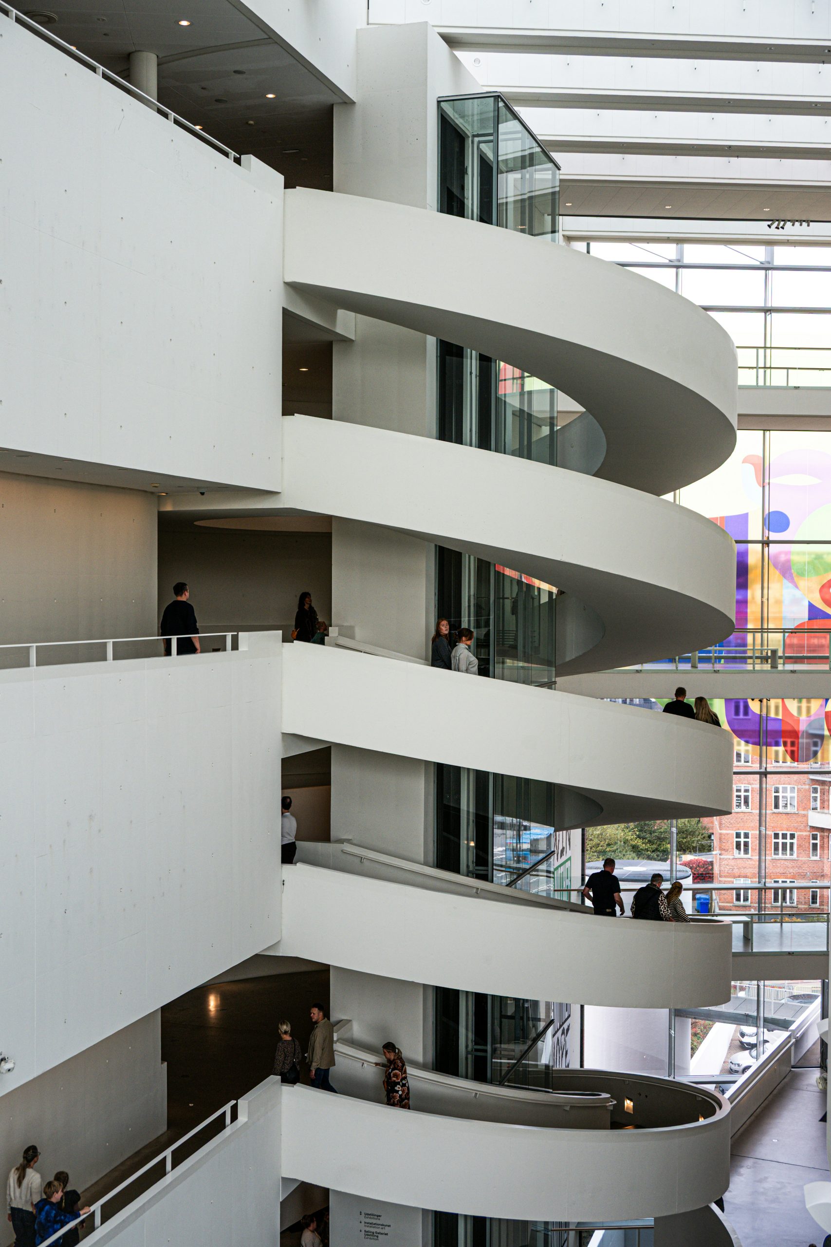 Visiteurs en mouvement dans l’architecture intérieure de l’ARoS Aarhus Art Museum.
